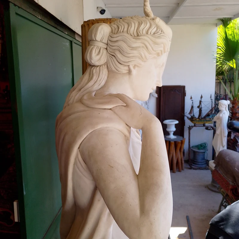 Large marble sculpture of a woman with flowers at her feet