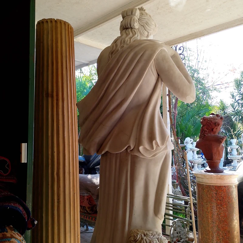 Large marble sculpture of a woman with flowers at her feet
