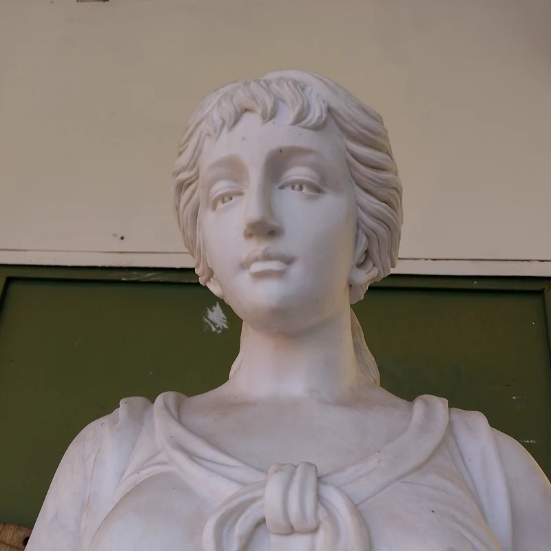 Large marble sculpture of a woman, wheat ears, and flower basket