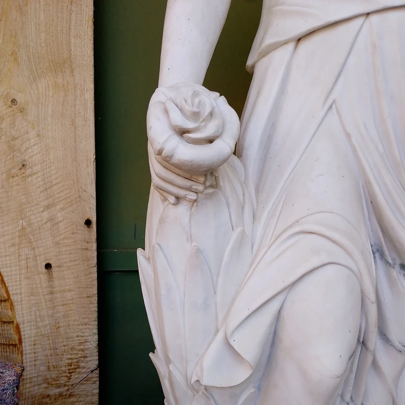 Large marble sculpture of a woman, wheat ears, and flower basket