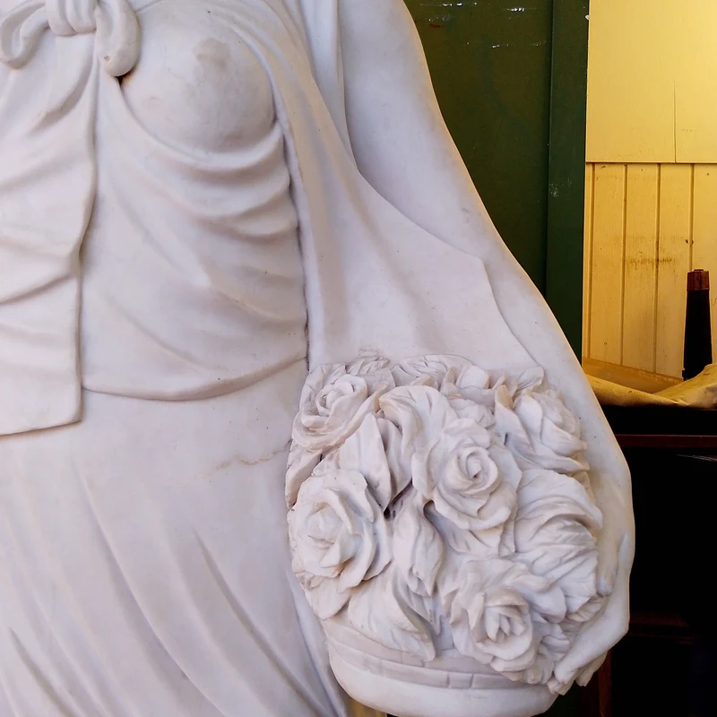 Large marble sculpture of a woman, wheat ears, and flower basket