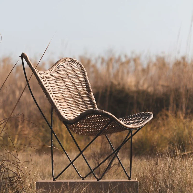 Contemporary Scandinavian Handwoven Rattan Lounge Chair - Accent Chair With Ergonomic Backrest & Iron Base For Boutique Indoor & Outdoor Spaces
