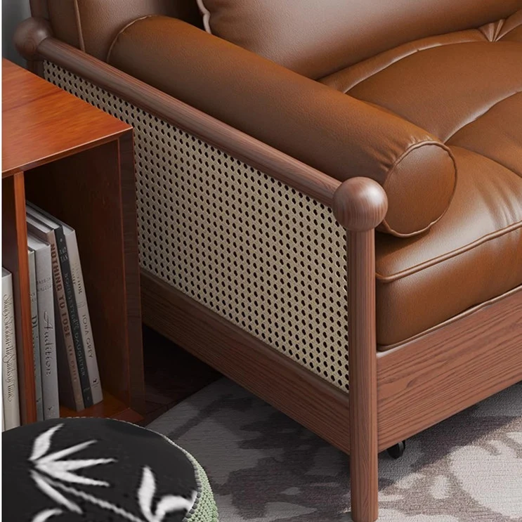 Sofá cama retro de cuero con reposabrazos de tejido de ratán y espacio de almacenamiento debajo.