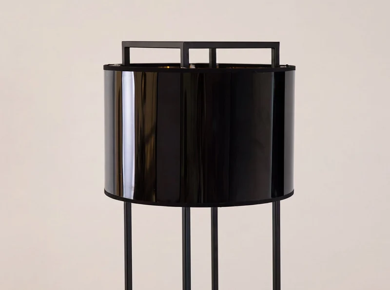 Black steel floor lamp with black PVC shade and gold interior